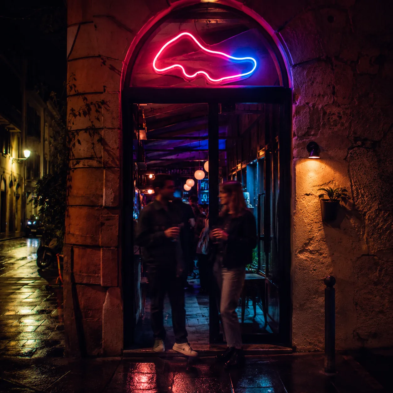 Eingang mit Neon-Logo bei Nacht