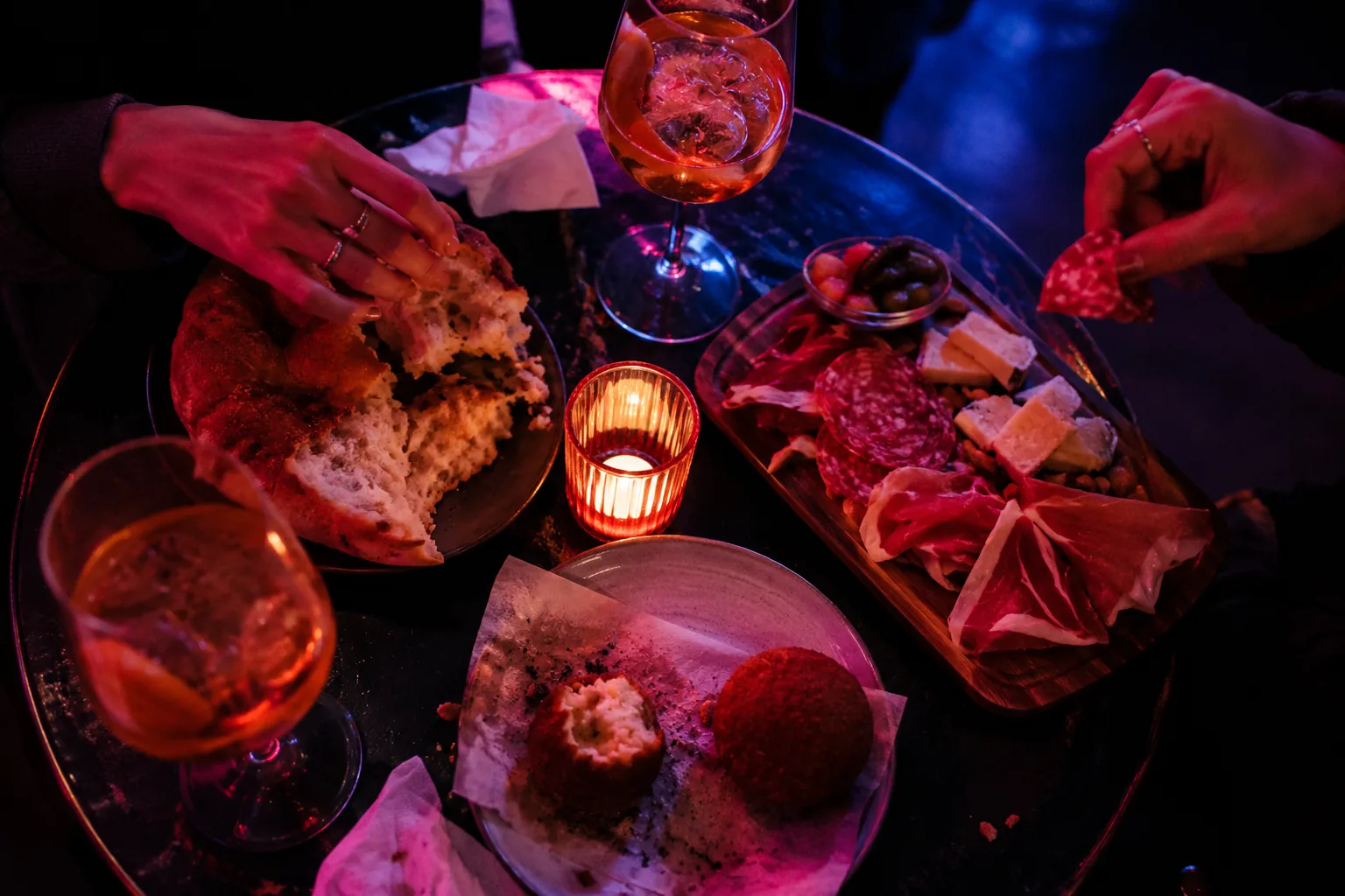Tisch von oben mit Focaccia, Arancini, Tagliere und zwei Spritz